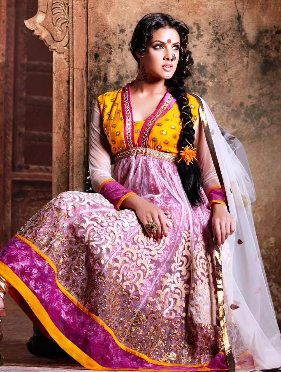 Woman wearing a colorful Indian salwar kameez with embroidered long tunic and matching dupatta